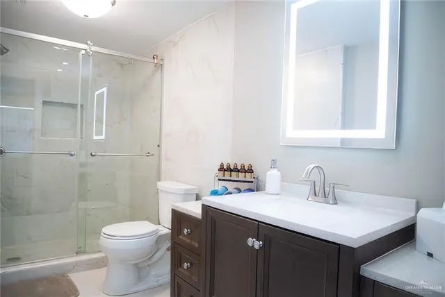 a bathroom with a sink a toilet and shower