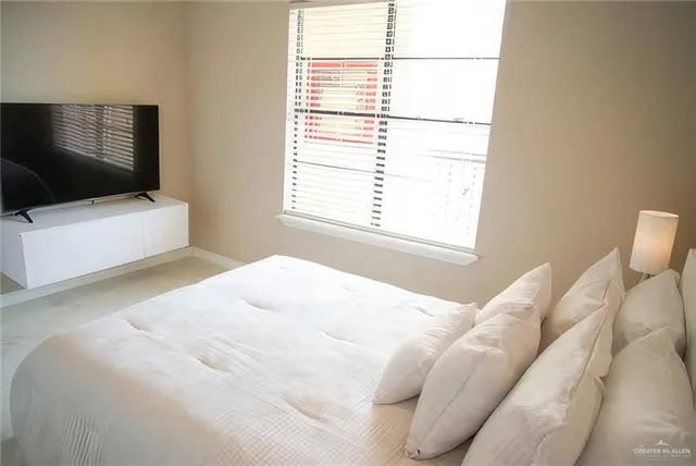 a bedroom with a bed and a flat screen tv