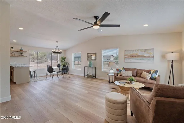 a kitchen with stainless steel appliances granite countertop white cabinets a sink a stove a refrigerator and microwave