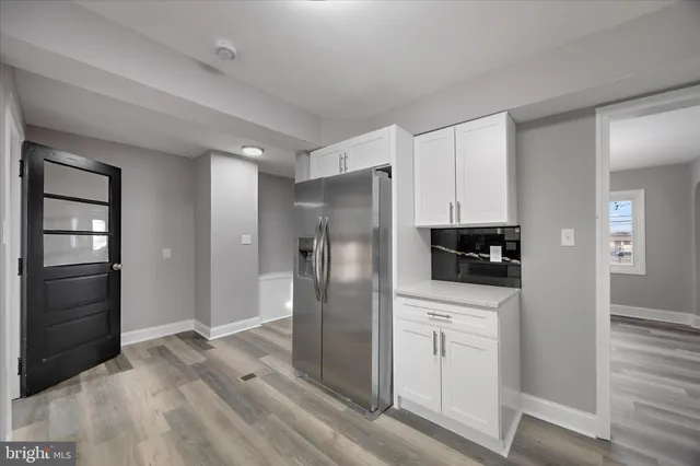 a kitchen with white cabinets appliances and sink