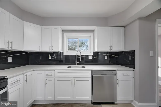 a kitchen with granite countertop a stove sink and cabinets