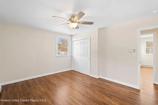 a view of a room with wooden floor closet and fan
