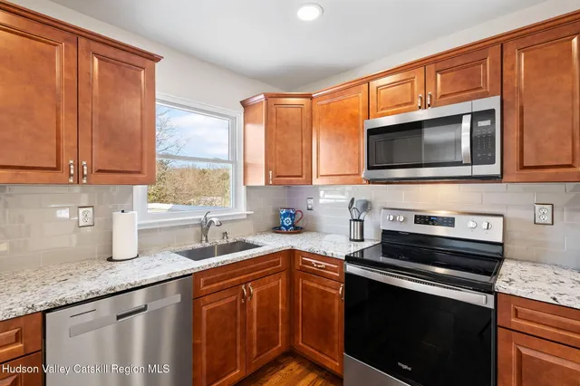a kitchen with stainless steel appliances granite countertop a stove sink microwave and cabinets