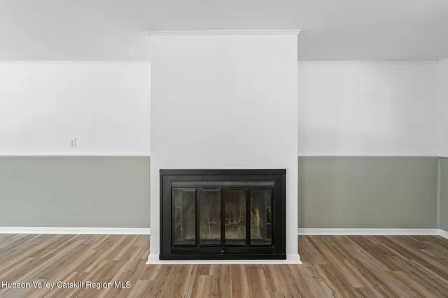 an empty room with wooden floor and fireplace