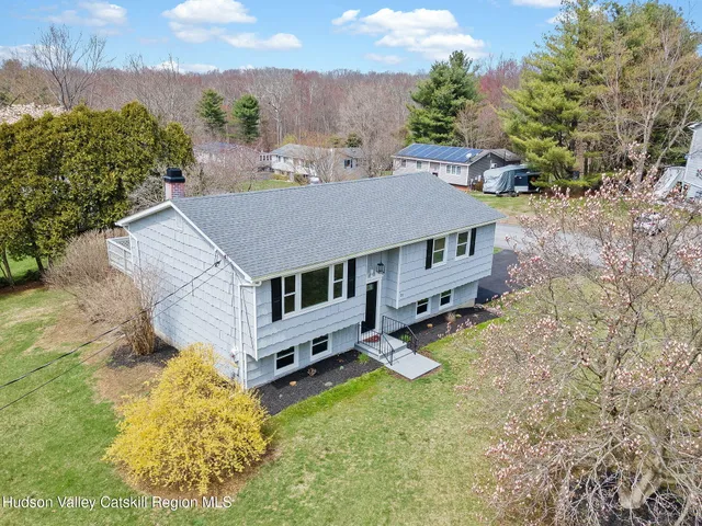 an aerial view of a house with a big yard and large trees