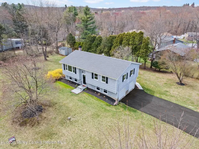 an aerial view of a house with yard and roof