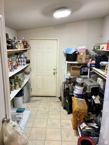 547 East 2000th Street North Vernal, UT 84078 - Photo 34 of 50 Spacious utility room featuring tile flooring, a four-panel interior door, recessed lighting, and extensive wall-mounted shelving for storage