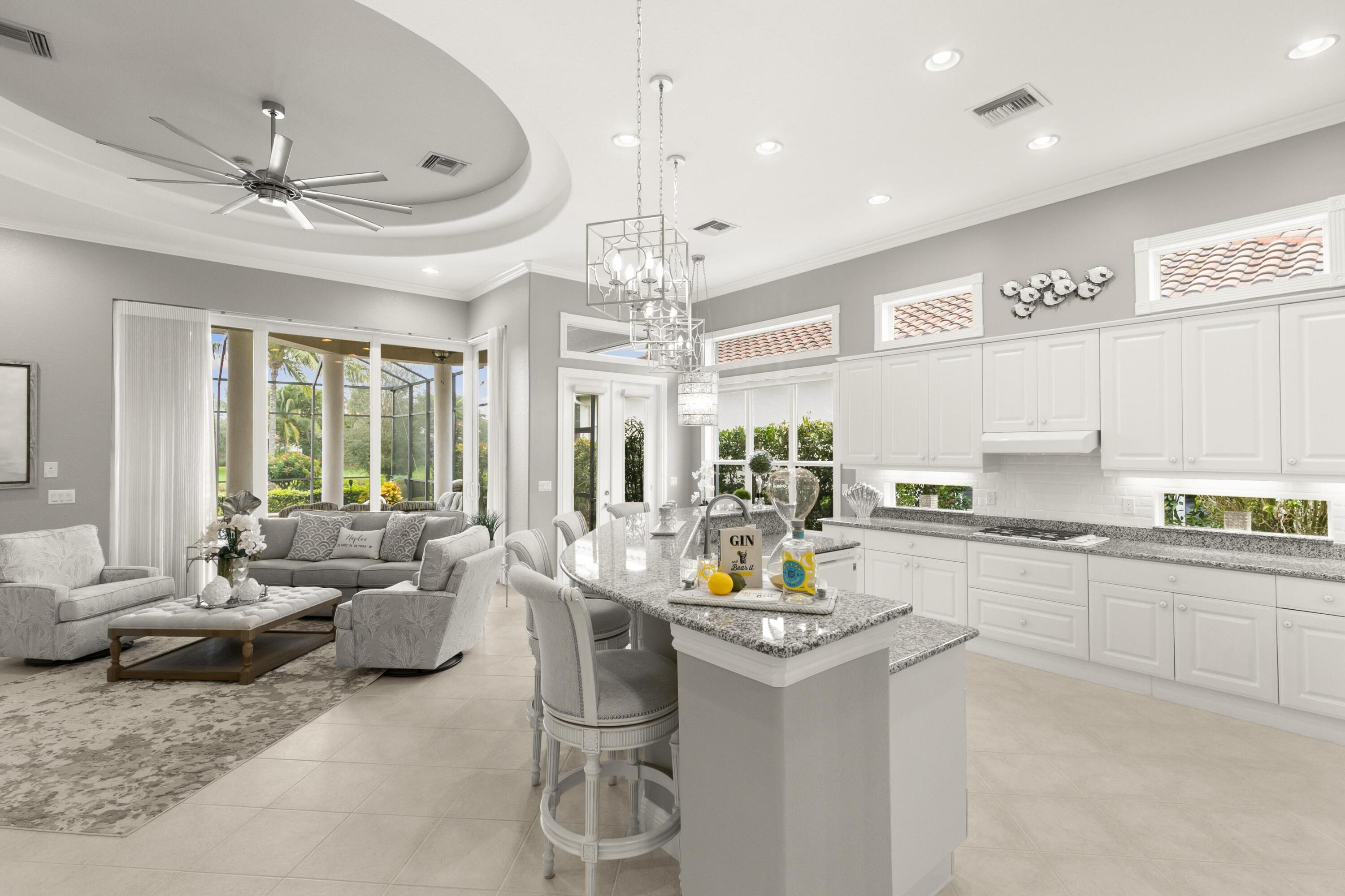 a open kitchen with stainless steel appliances granite countertop a refrigerator a sink dishwasher a dining table and chairs with wooden floor