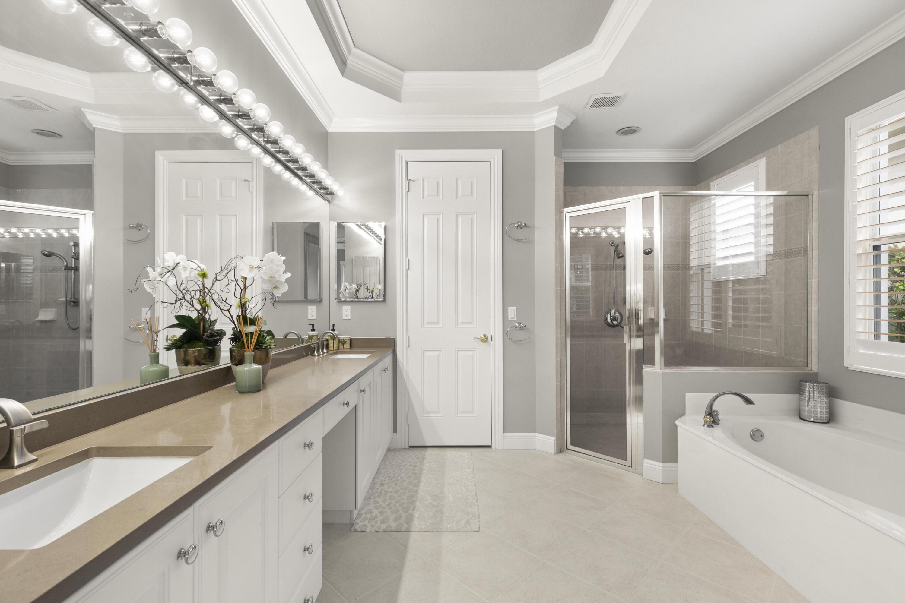 9100 Cherry Oaks Trail Naples, FL 34114 - Photo 17 of 33 a bathroom with a granite countertop sink a large mirror a bathtub and next to a window