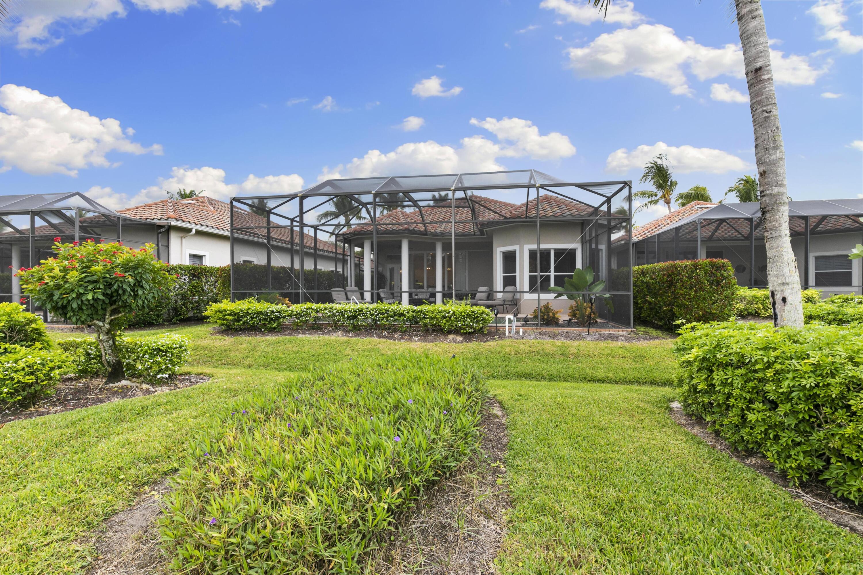 9100 Cherry Oaks Trail Naples, FL 34114 - Photo 26 of 33 a front view of a building with a garden