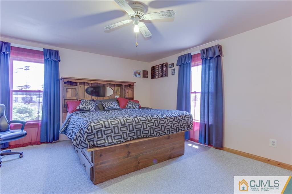 659 Ridge Road Monmouth Junction, NJ 08852 - Photo 17 of 24 a spacious bedroom with a bed and a chandelier
