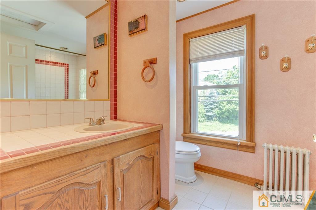 659 Ridge Road Monmouth Junction, NJ 08852 - Photo 18 of 24 a bathroom with a granite countertop sink a toilet and a mirror