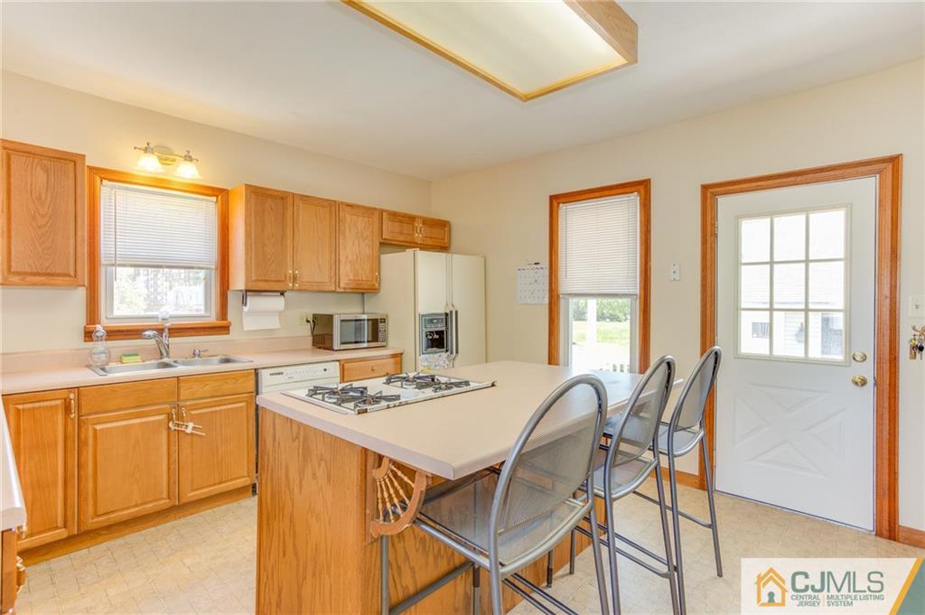 659 Ridge Road Monmouth Junction, NJ 08852 - Photo 9 of 24 a kitchen with a stove a sink a refrigerator and cabinets