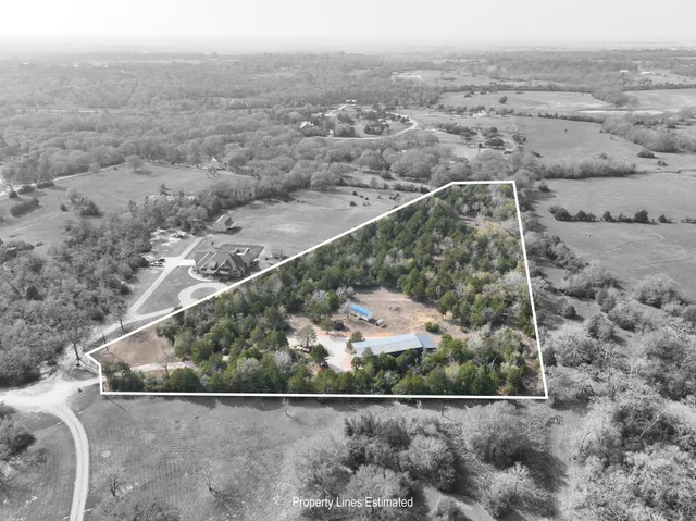 an aerial view of house with yard and mountain view in back