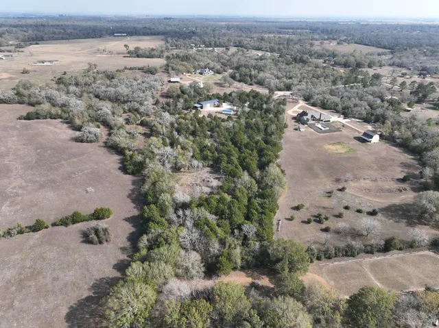 an aerial view of residential house with outdoor space and trees around