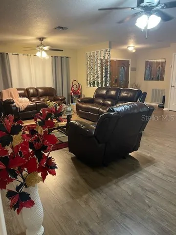 a living room with furniture flowers and a chandelier