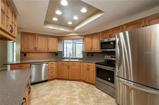 a kitchen with granite countertop stainless steel appliances and wooden cabinets