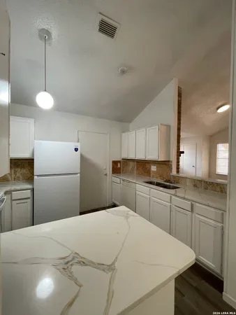 a kitchen with a white cabinets appliances and sink