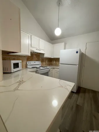 a kitchen with refrigerator and microwave