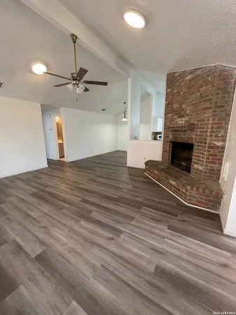 a view of empty room with wooden floor and fireplace