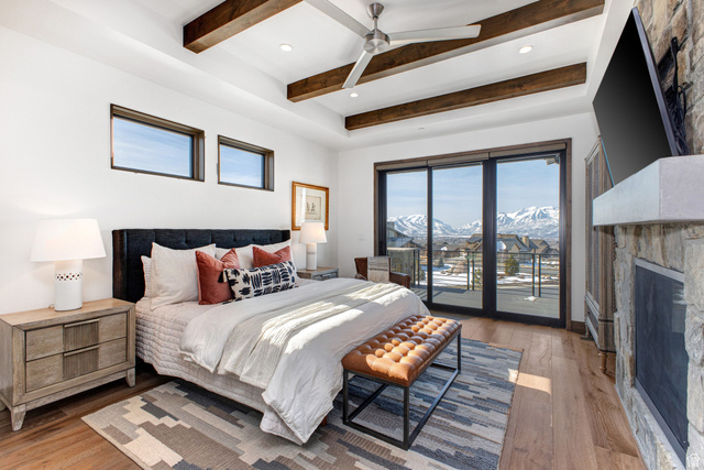 1282 Chimney Rock Road, Unit 344 Heber City, UT 84032 - Photo 25 of 55 Bedroom featuring a stone fireplace, wood-finish flooring, and a ceiling fan