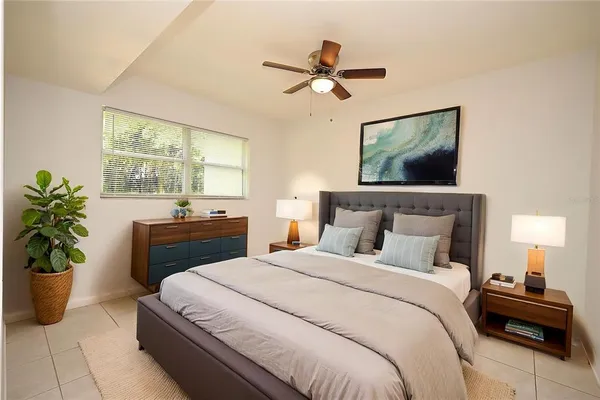 a bedroom with a bed and a potted plant