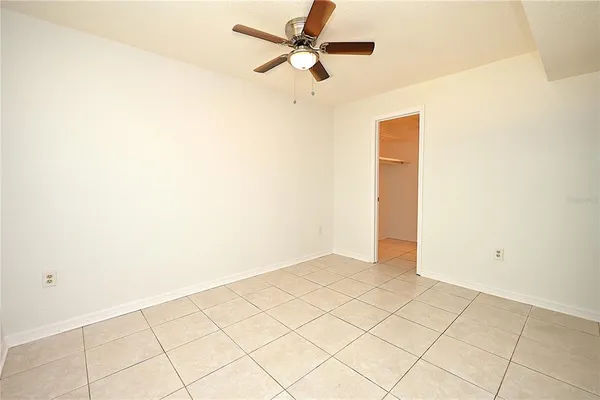 an empty room with a ceiling fan and a window