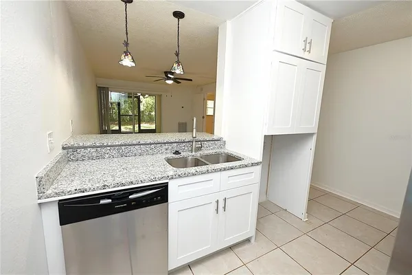 a view of a kitchen counter space a sink dishwasher and wooden floor