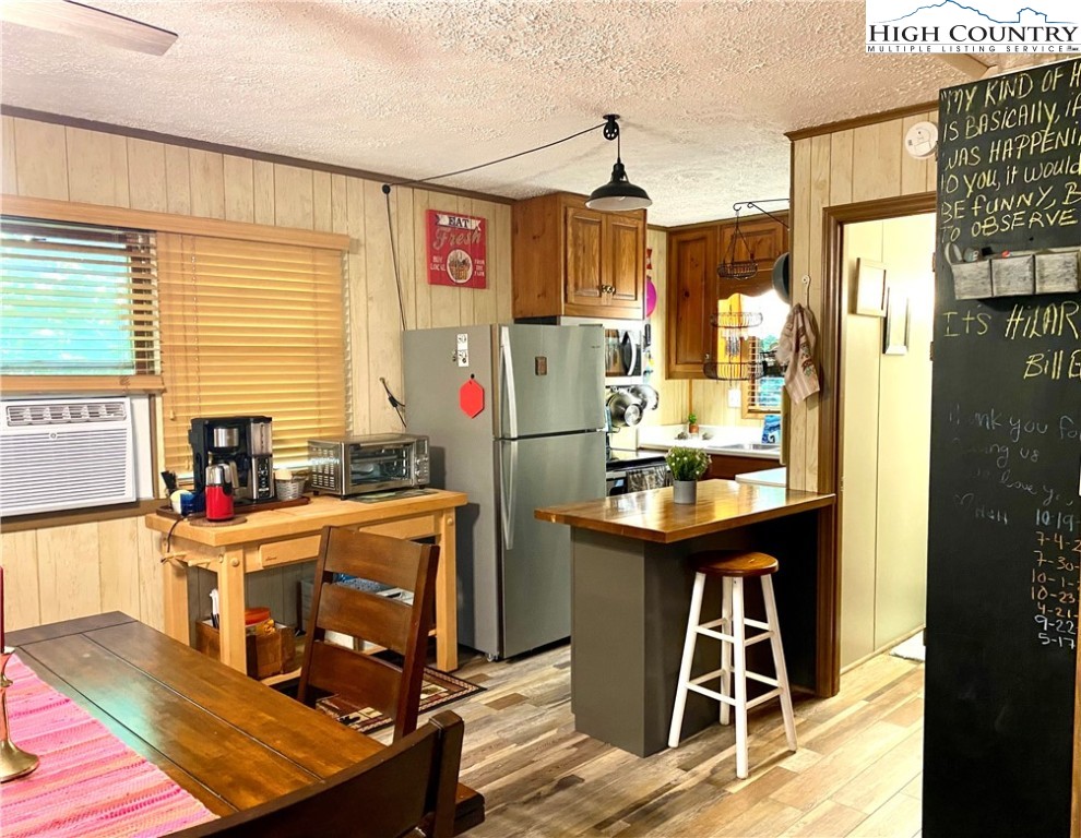 175 Ash Loop Newland, NC 28657 - Photo 17 of 46 a kitchen with stainless steel appliances granite countertop a refrigerator a sink dishwasher a stove and a dining table with wooden floor