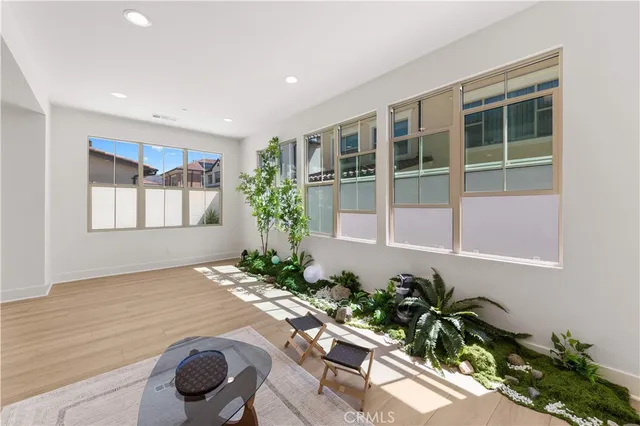 a large white kitchen with stainless steel appliances kitchen island a large counter top and a wooden floors