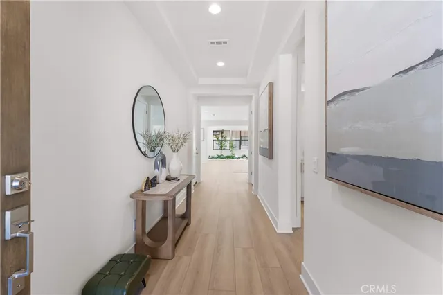 a view of a hallway with entryway wooden floor and front door