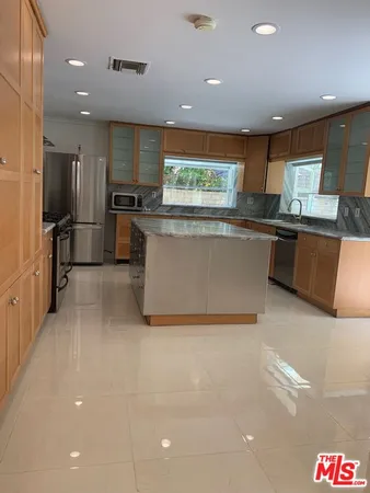 a kitchen with stainless steel appliances granite countertop a sink and a refrigerator