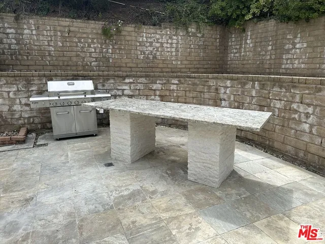 a view of a yard with plants and a bench