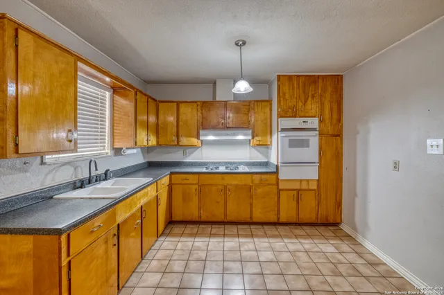 a large kitchen with stainless steel appliances granite countertop a sink and cabinets