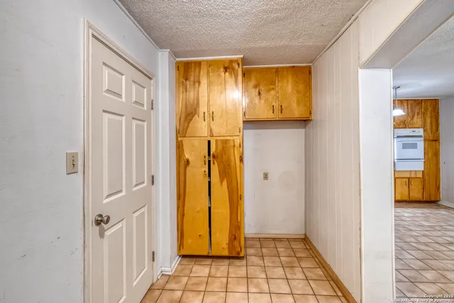 a view of a hallway with wooden floor and a bathroom