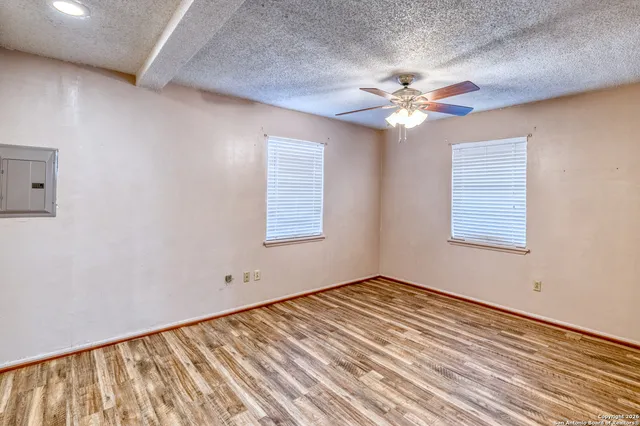 a view of empty room with window and ceiling fan
