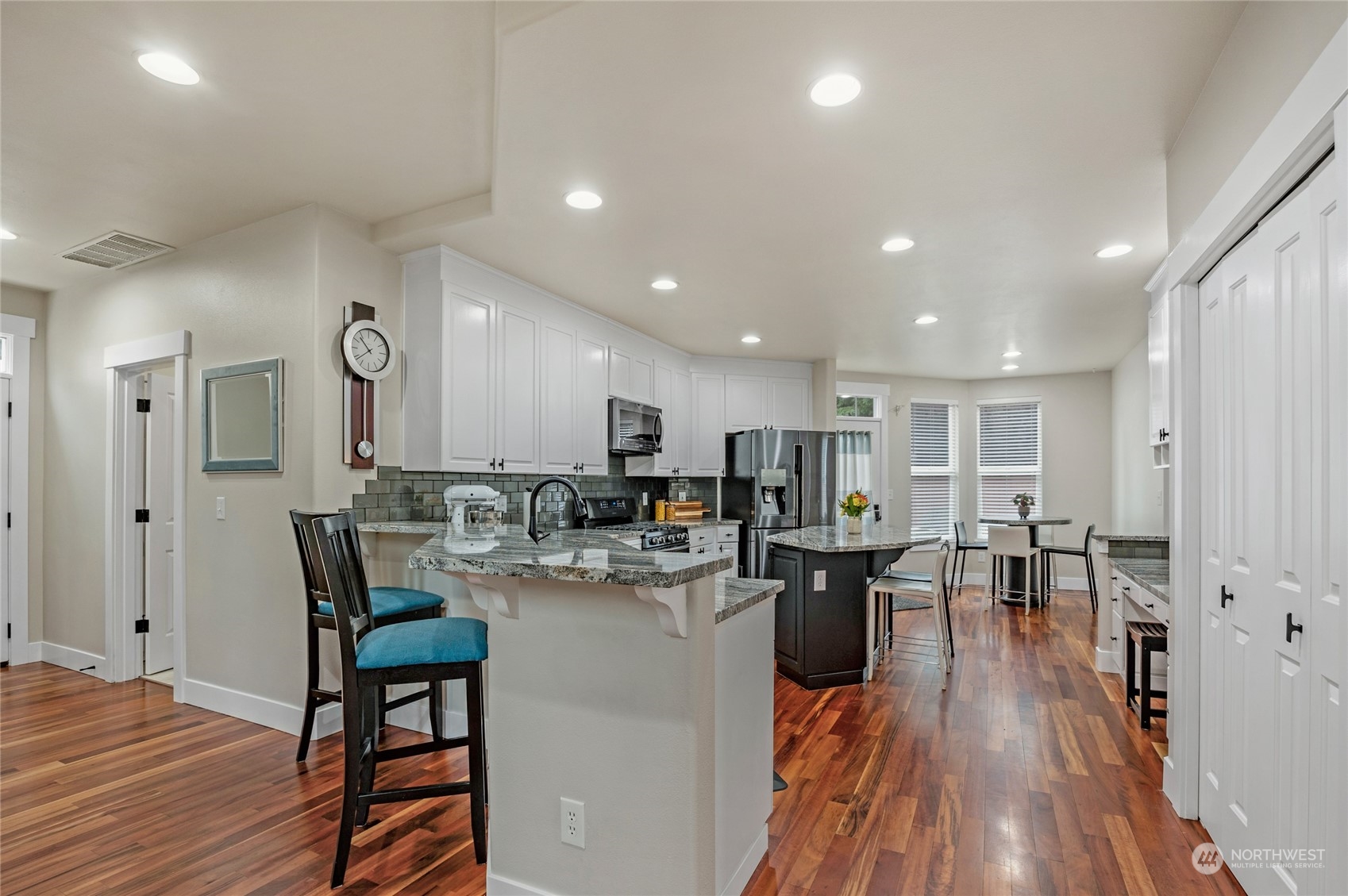 18712 33rd Avenue Southeast Bothell, WA 98012 - Photo 11 of 39 a view of a dining room and livingroom with furniture wooden floor a rug a fireplace and windows