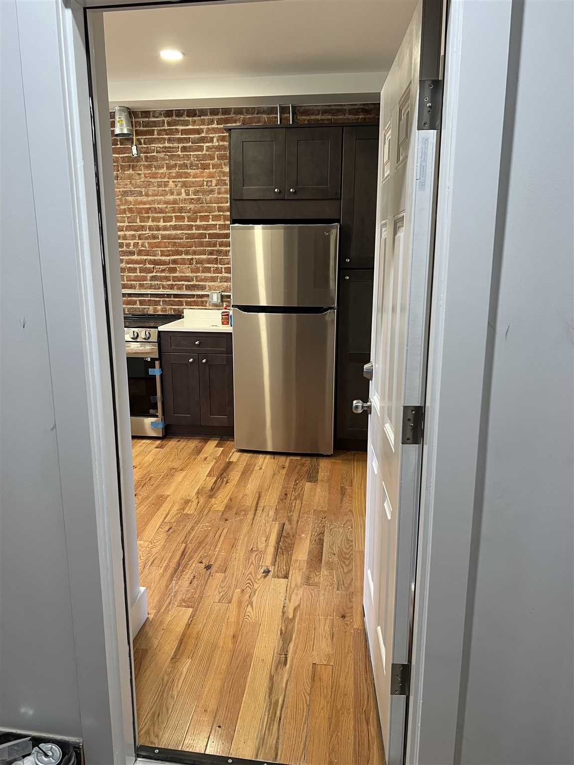 195 Main Street, Unit 2 Beacon, NY 12508 - Photo 4 of 8 a view of a kitchen with wooden floor and electronic appliances