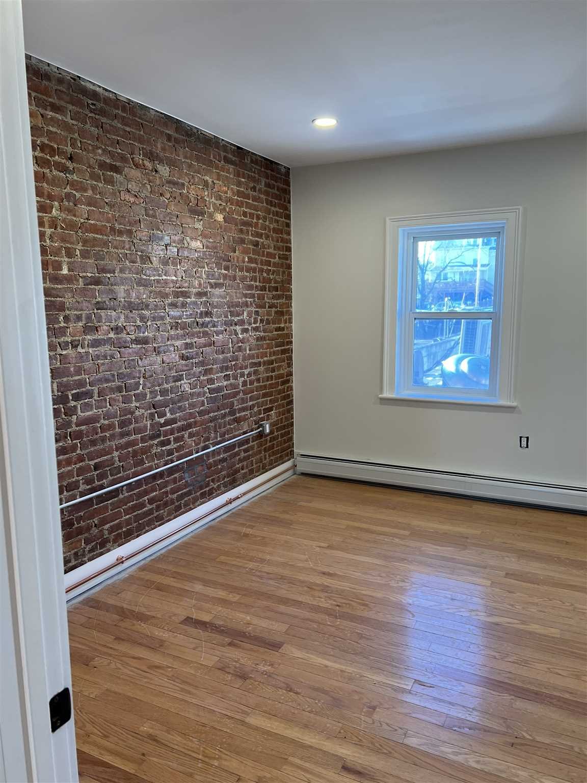195 Main Street, Unit 2 Beacon, NY 12508 - Photo 6 of 8 a view of an empty room with wooden floor and a window