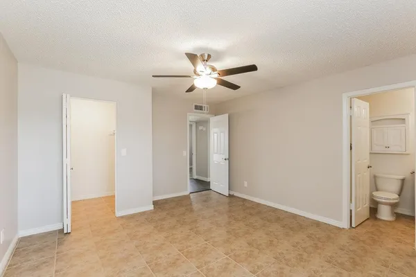 a view of a room with a ceiling fan and a bathroom