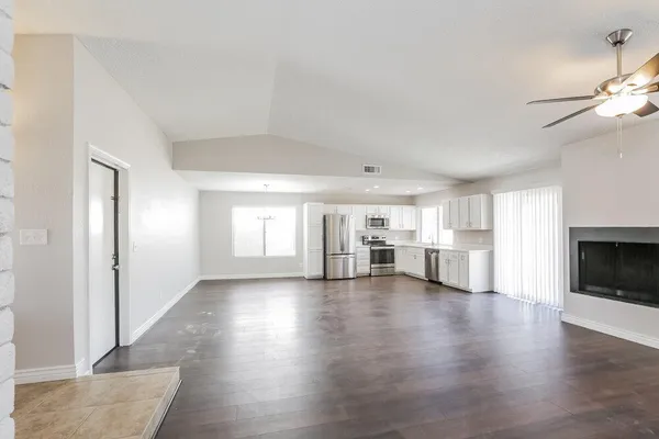 a view of empty room with wooden floor and fireplace