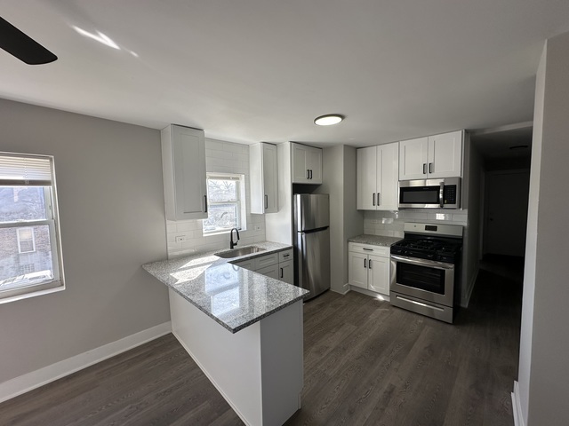 6924 South Aberdeen Street, Unit 2 Chicago, IL 60621 - Photo 2 of 10 a kitchen with stainless steel appliances granite countertop a refrigerator a stove top oven a sink and dishwasher
