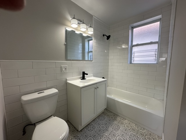 6924 South Aberdeen Street, Unit 2 Chicago, IL 60621 - Photo 6 of 10 a bathroom with a toilet a sink and bathtub