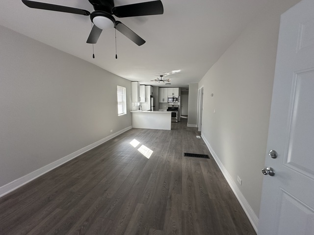 6924 South Aberdeen Street, Unit 2 Chicago, IL 60621 - Photo 7 of 10 a view of a hallway with wooden floor and a ceiling fan