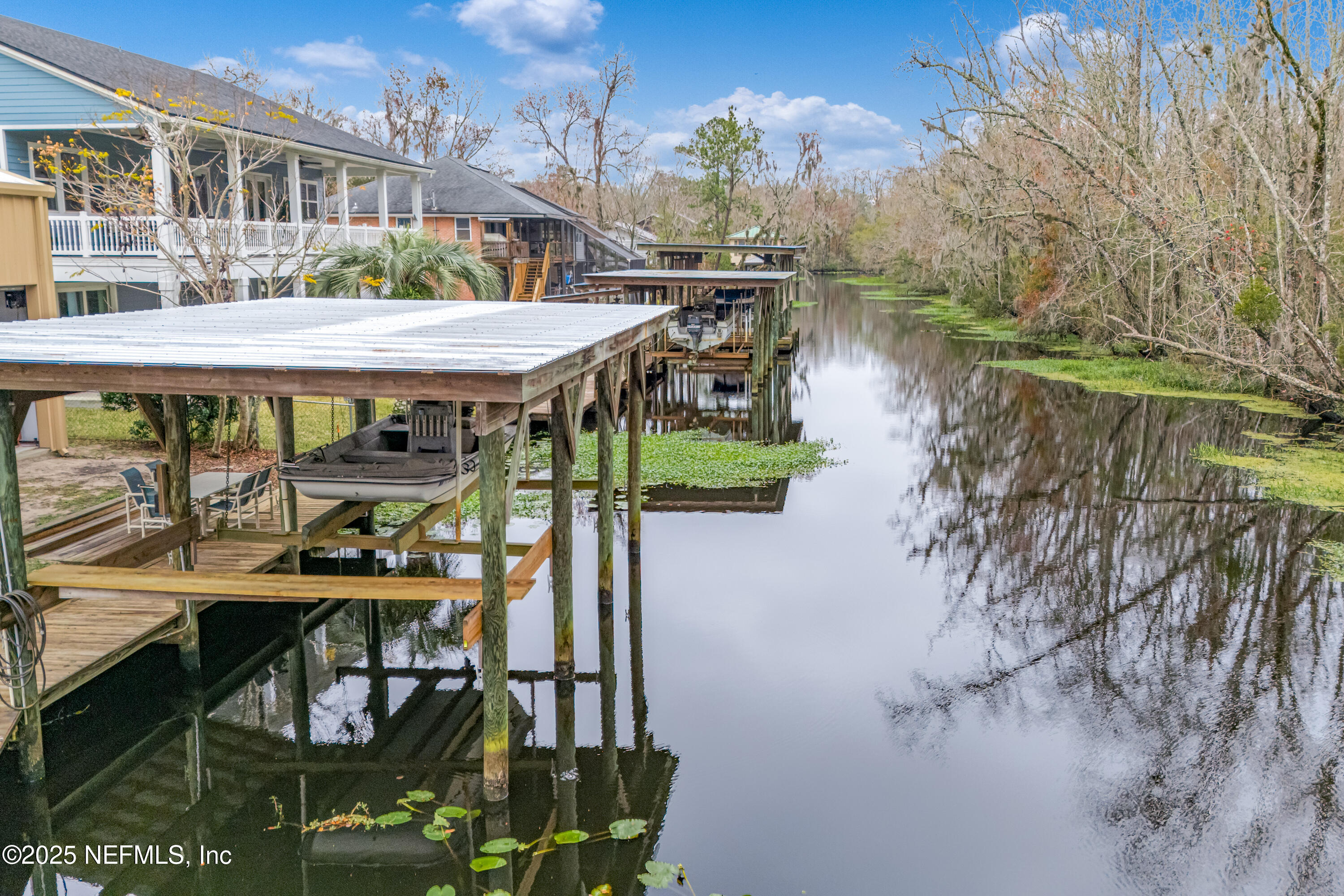 12932 Helm Drive Jacksonville, FL 32258 - Photo 29 of 42 a view of a patio with table and chairs under an umbrella with large trees