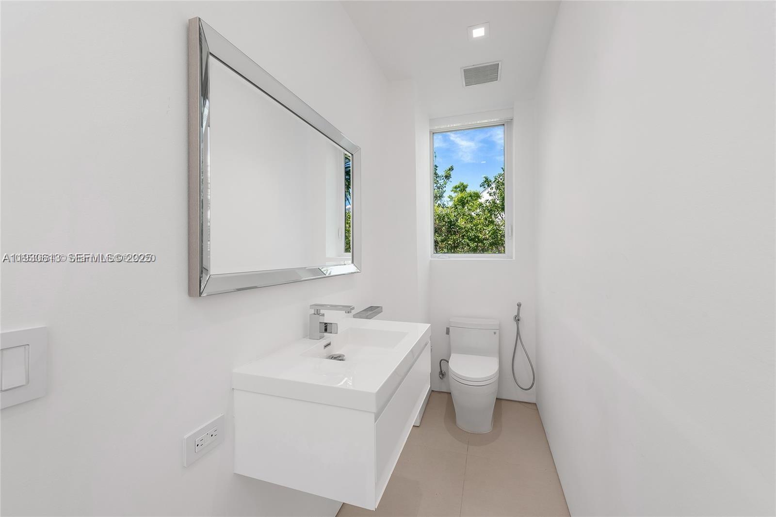 481 South Mashta Drive Key Biscayne, FL 33149 - Photo 21 of 57 a bathroom with a sink a toilet and mirror