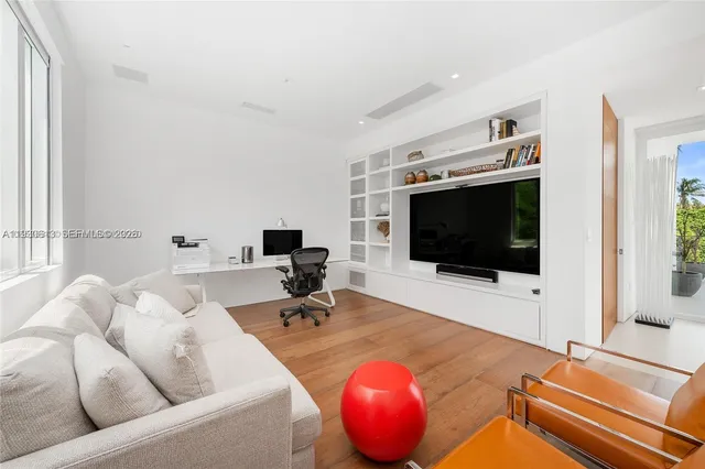 a bedroom with a large bed and windows