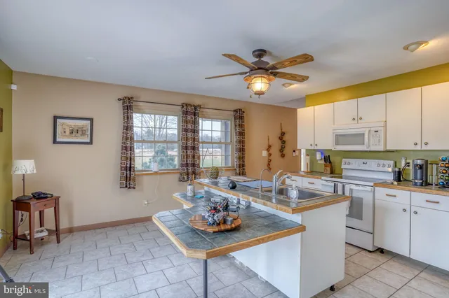 a view of an empty room with window and chandelier fan