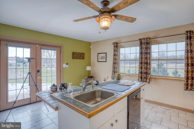 an empty room with windows and fan