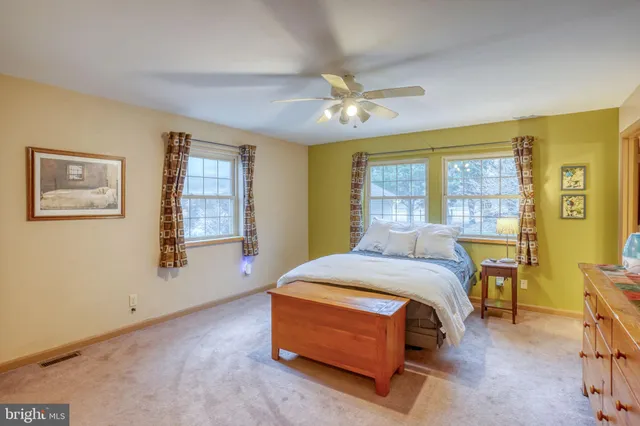 a view of an empty room with window and chandelier fan